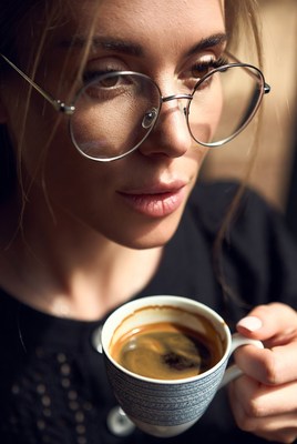 Woman drinking espresso with glasses