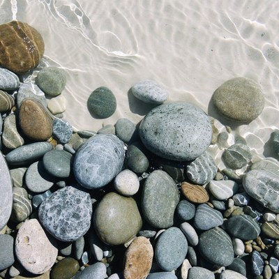 Colorful pebbles on shallow beach water