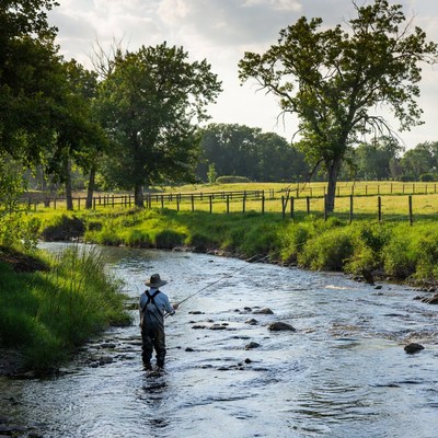 Man fishing in shallow river