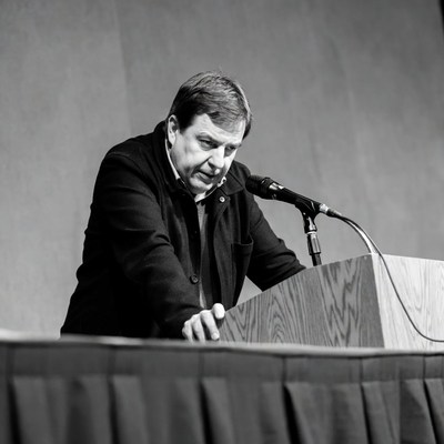 Man speaking at wooden podium