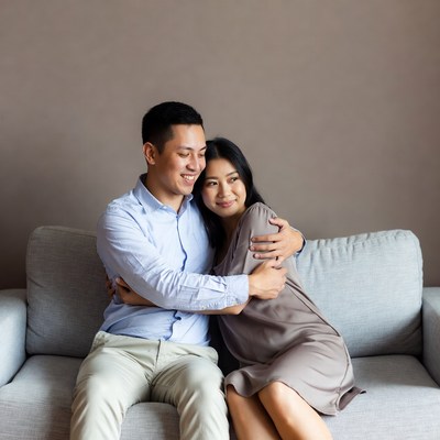 Asian couple hugging on sofa