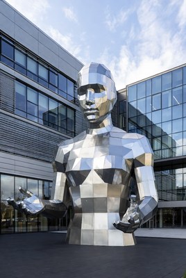 Giant metallic male statue outside building