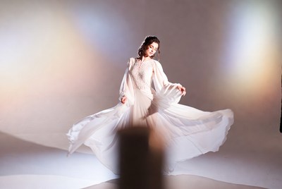 Woman in flowing white gown dancing