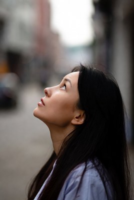 Asian woman looking up on street