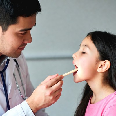 Doctor examining girl's throat