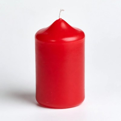 Red pillar candle with lit wick