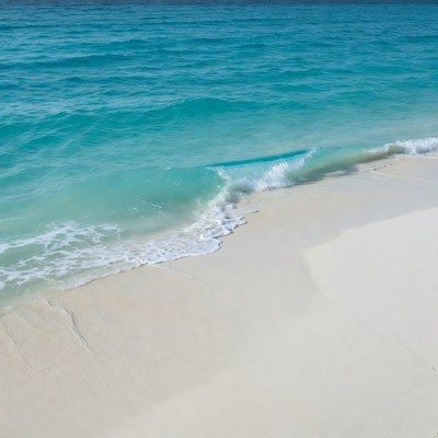 Turquoise ocean waves on white sand beach