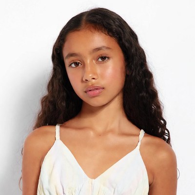 Young girl with curly hair in tie-dye dress