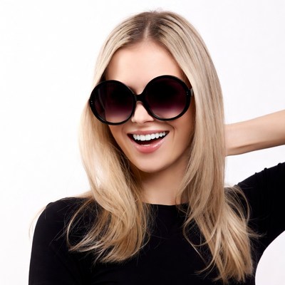 Blonde woman smiling in oversized sunglasses