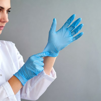 Woman putting on blue gloves
