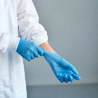 Woman putting on blue gloves