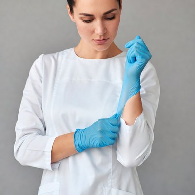 Woman putting on blue gloves