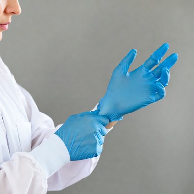Woman putting on blue gloves