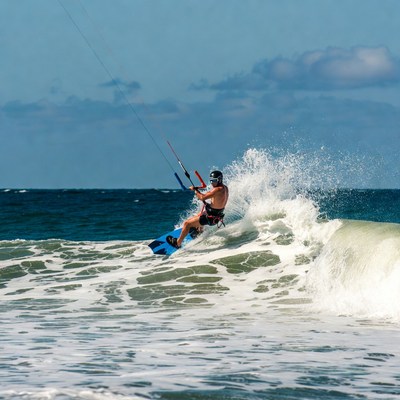 Man kitesurfing on ocean wave