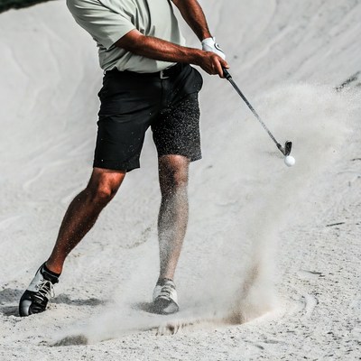 Man hitting golf ball from sand trap