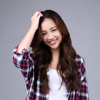 Asian woman scratching head smiling