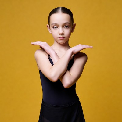Girl crossing arms on yellow background