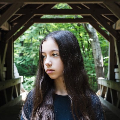 Girl standing in wooden bridge