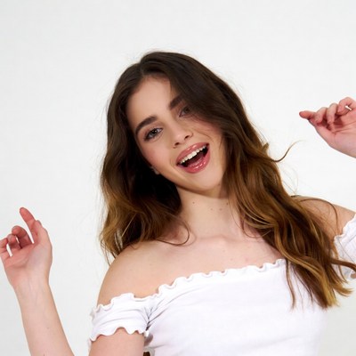 Teen girl smiling with hands raised