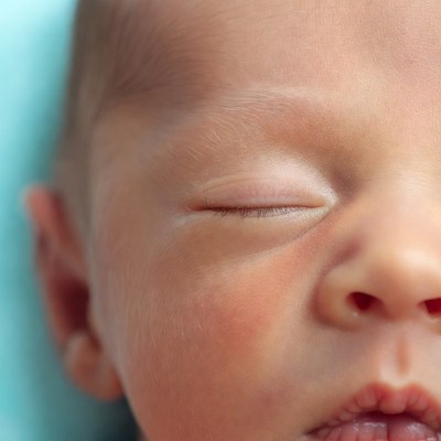 Newborn baby sleeping with one eye open