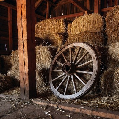 Old wagon wheel against hay bales