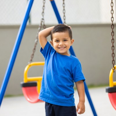 Smiling Latino boy at playground swings
