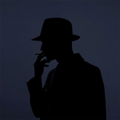 Silhouette man smoking cigarette in fedora