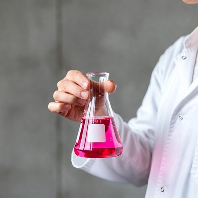 Scientist holding pink liquid flask