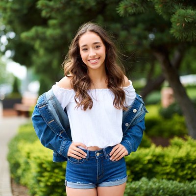 Smiling teenage girl in denim outfit outdoors