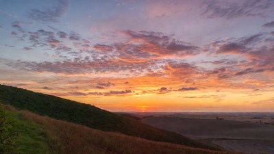Sunset over grassy hills