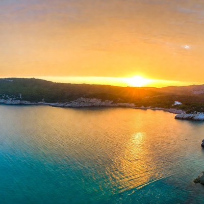 Sunset over turquoise bay and hills