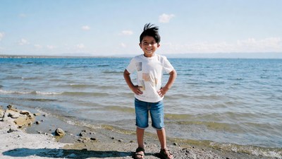 Asian boy standing on lakeside beach