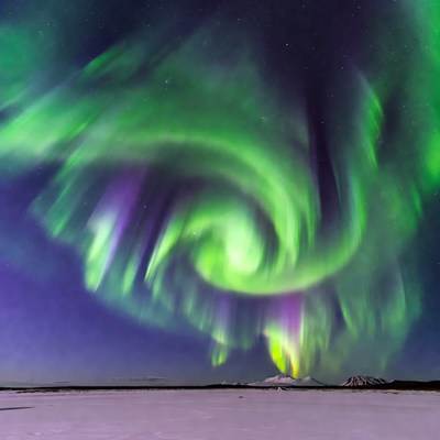 Swirling Northern Lights over Snowy Mountain