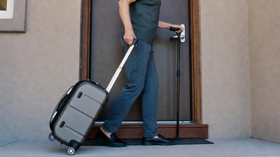 Man with cane pulling suitcase at door