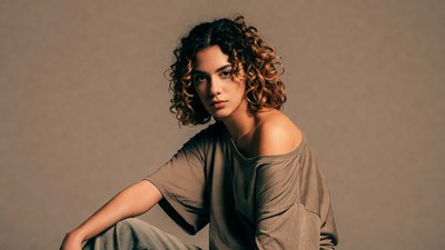Curly-haired woman in off-shoulder top