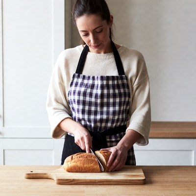 Woman slicing bread in kitchen