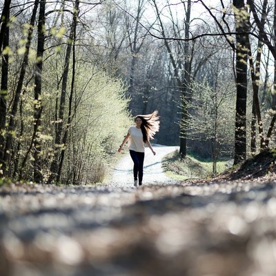 Woman walking on forest path
