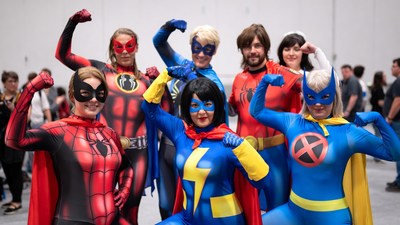 Group of superhero cosplayers flexing muscles
