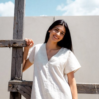 Smiling woman leaning on wooden post