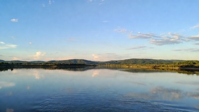 Calm lake reflecting green mountains