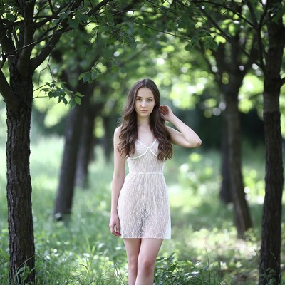 Young woman in sheer dress in forest