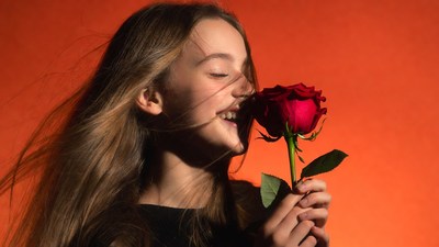Girl smelling red rose