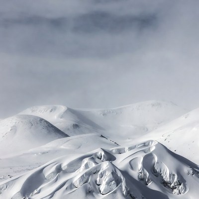 Snowy Mountain Peaks Under Cloudy Sky