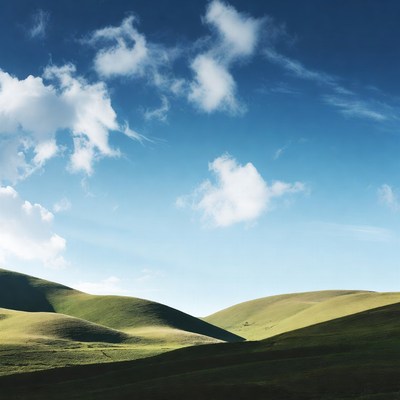 Green Rolling Hills Under Blue Sky