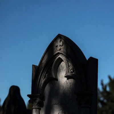 Gothic gravestone against blue sky
