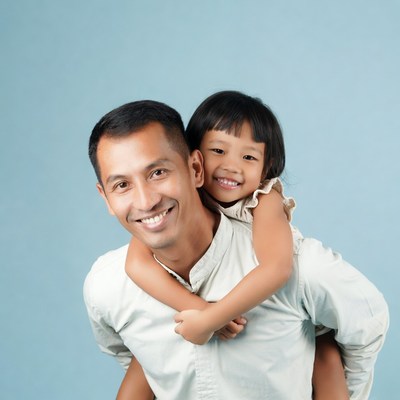 Asian father piggybacking smiling daughter