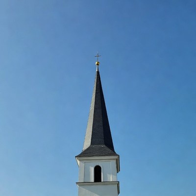 Church Steeple with Cross Against Blue Sky