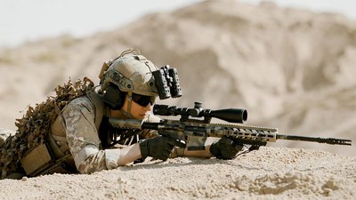 Soldier aiming sniper rifle in desert