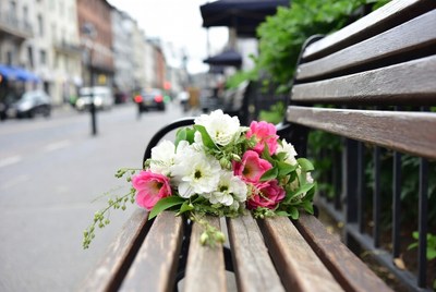 Bouquet of white and pink flowers on park bench