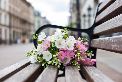 Bouquet of white and pink flowers on park bench